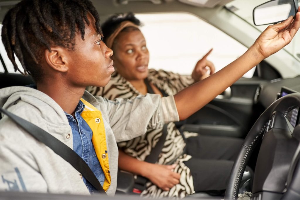 A teenager driving with their parent.